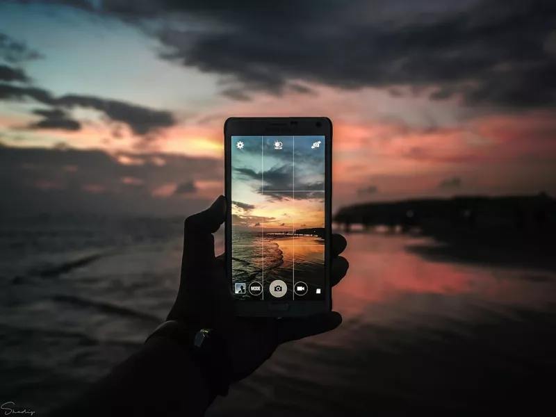 Phone capturing a sunset over the sea